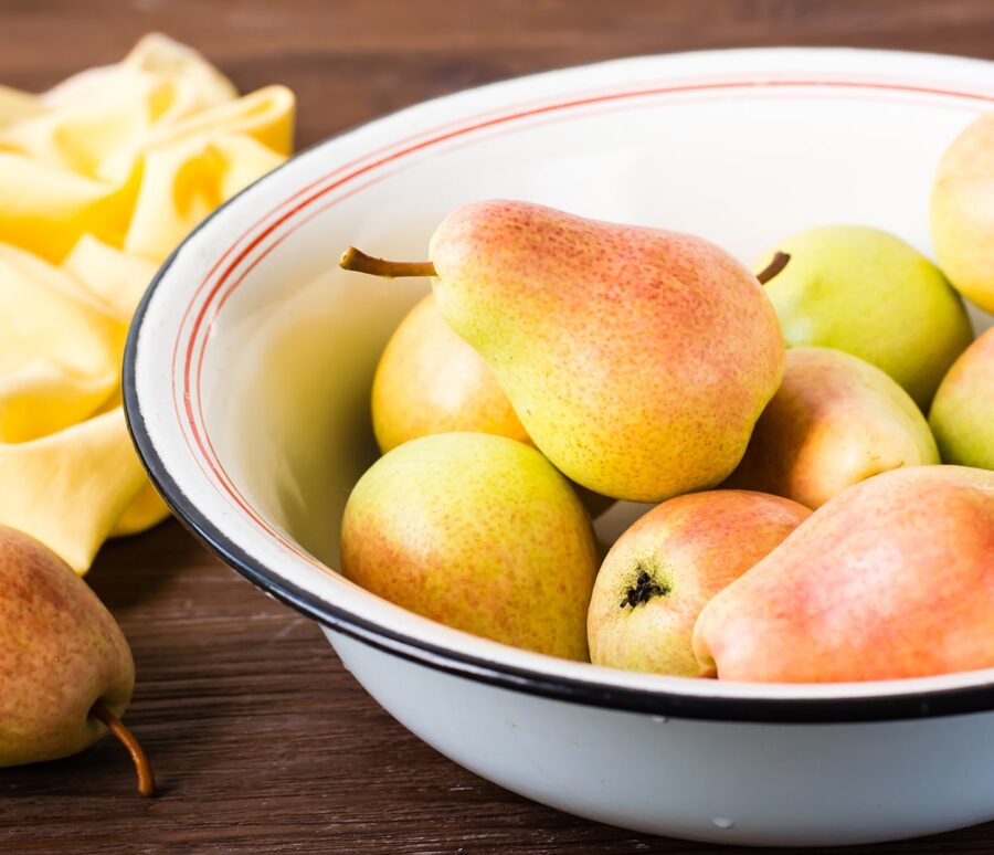 ripe-pears-in-an-enamel-plate-on-a-wooden-table-2023-11-27-04-56-29-utc-min